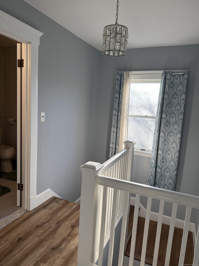 stairs featuring an inviting chandelier and hardwood / wood-style floors