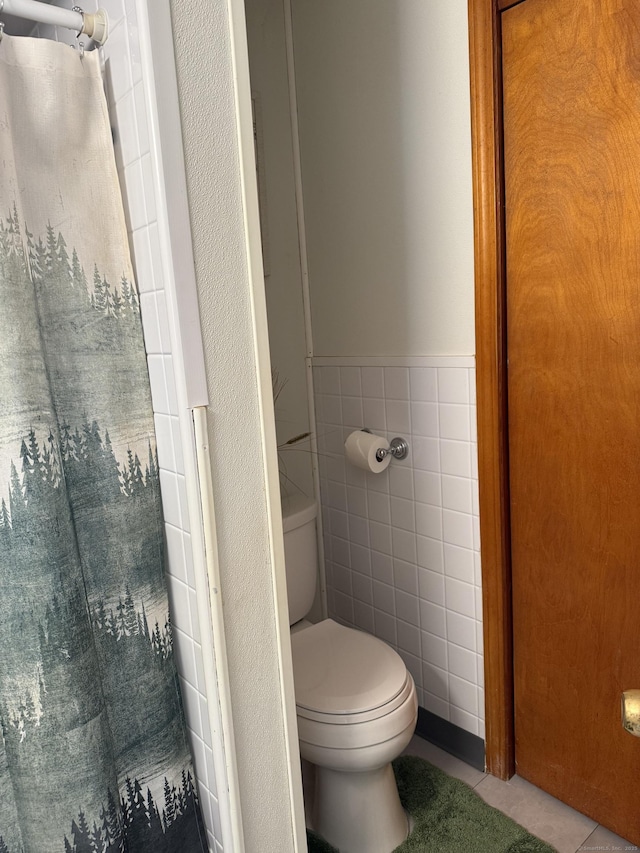 bathroom with tile walls, tile patterned flooring, and toilet