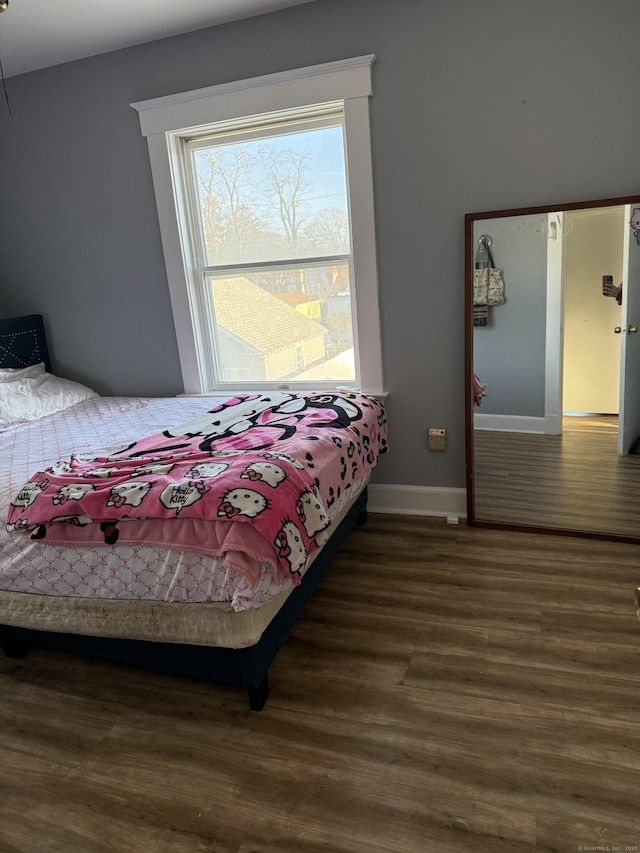 bedroom with dark hardwood / wood-style flooring