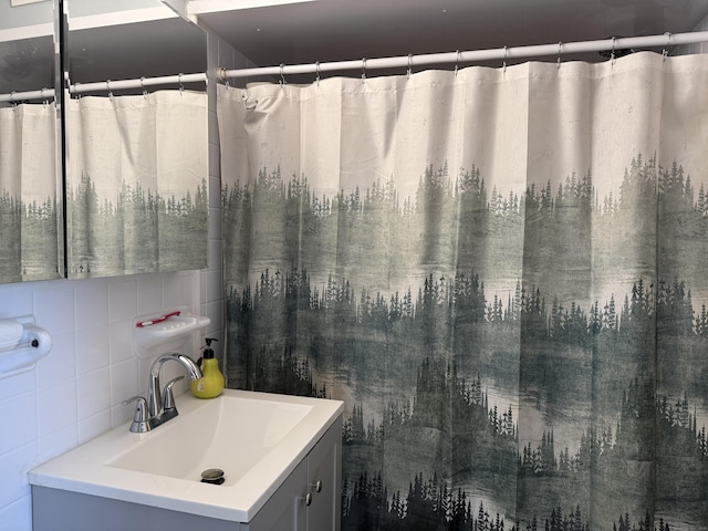 bathroom with tasteful backsplash, vanity, and tile walls