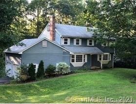 42 Windham Dr, Simsbury, CT 06070 - traditional home with a chimney, a front yard, and a garage