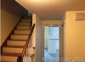 staircase featuring a textured ceiling