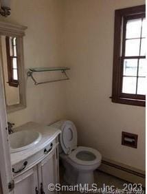42 Windham Dr, Simsbury, CT 06070 - half bathroom with vanity, toilet, and a baseboard heating unit