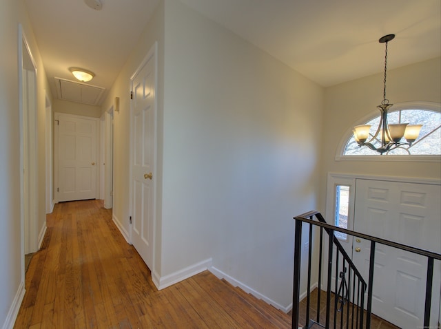 foyer entrance featuring a notable chandelier, wood-type flooring, and a wealth of natural light