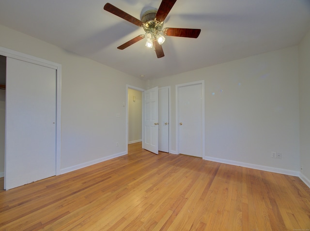 unfurnished bedroom with multiple closets, ceiling fan, and light hardwood / wood-style flooring