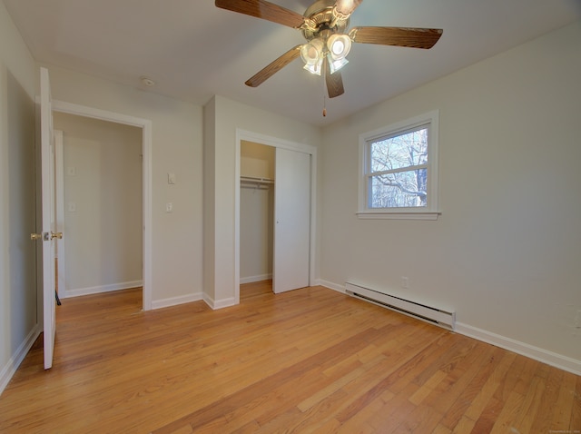 unfurnished bedroom with ceiling fan, a closet, a baseboard radiator, and light hardwood / wood-style floors