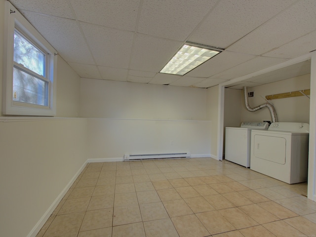 washroom with washing machine and dryer, light tile patterned floors, and a baseboard radiator