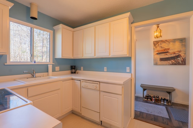 kitchen with dishwasher, sink, hanging light fixtures, light hardwood / wood-style floors, and white cabinets