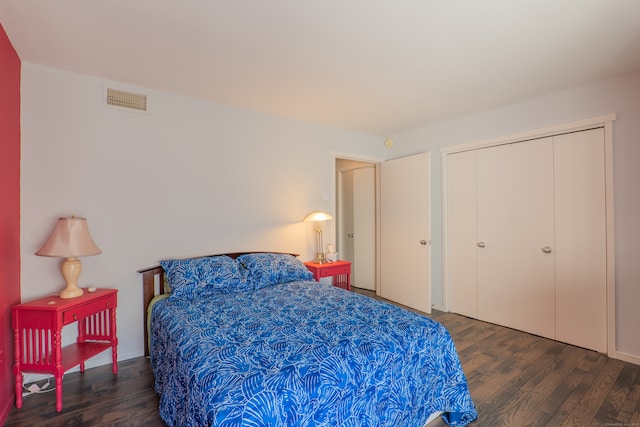 bedroom with dark hardwood / wood-style flooring and a closet