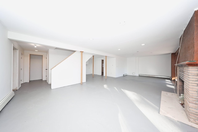 basement with a brick fireplace and a baseboard heating unit