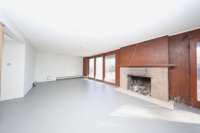 unfurnished living room with baseboard heating, a fireplace, and concrete flooring