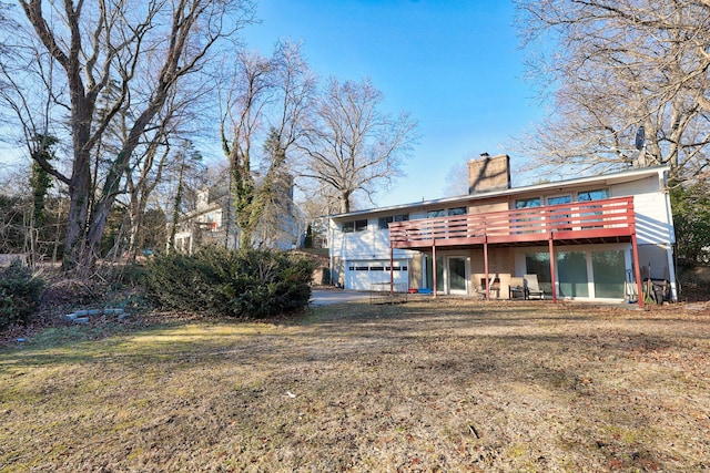 rear view of house featuring a garage and a wooden deck