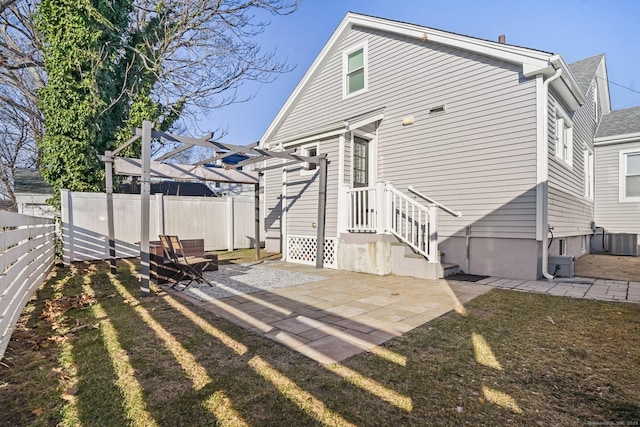 rear view of house featuring a patio, central AC, a lawn, and a pergola