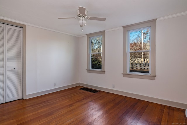 unfurnished bedroom featuring hardwood / wood-style flooring, ceiling fan, ornamental molding, and a closet