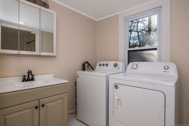 laundry room with cabinets, washing machine and dryer, ornamental molding, and sink