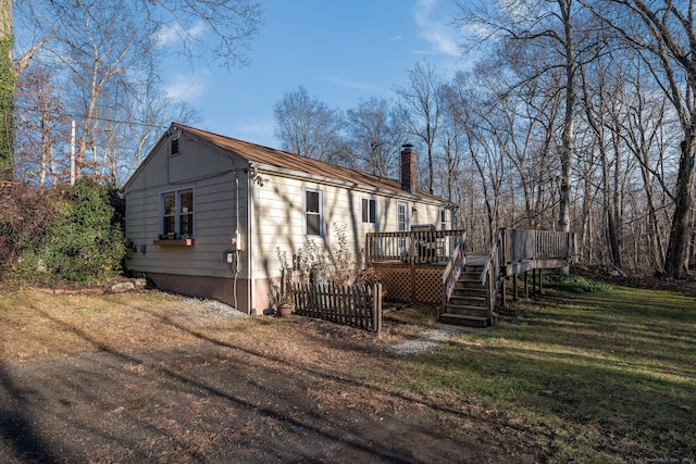 exterior space featuring a front lawn and a wooden deck