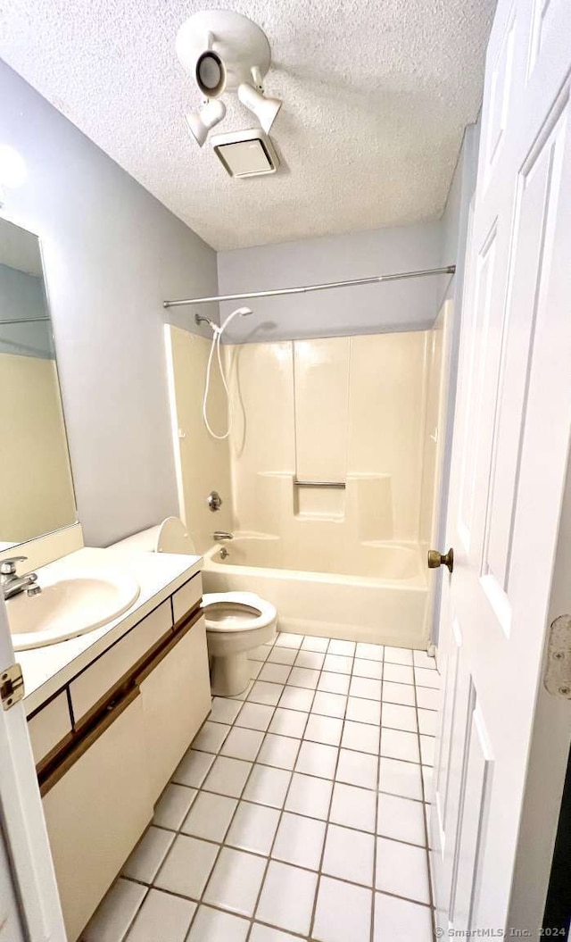 full bathroom featuring  shower combination, tile patterned flooring, a textured ceiling, and toilet