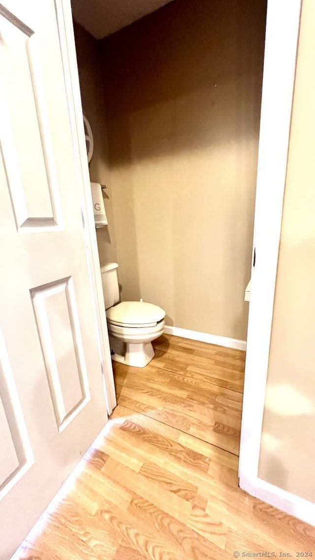 bathroom featuring hardwood / wood-style flooring and toilet