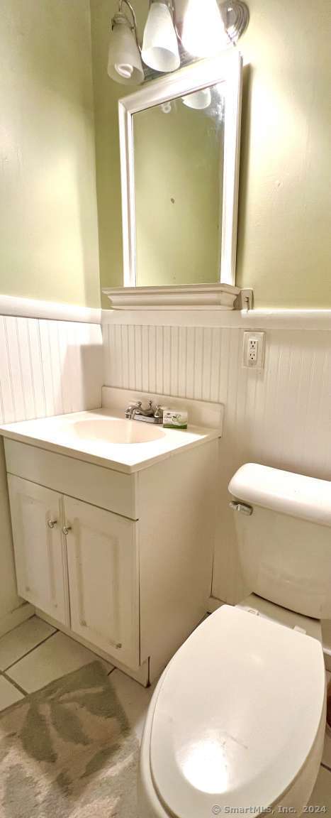 bathroom featuring tile patterned flooring, vanity, and toilet