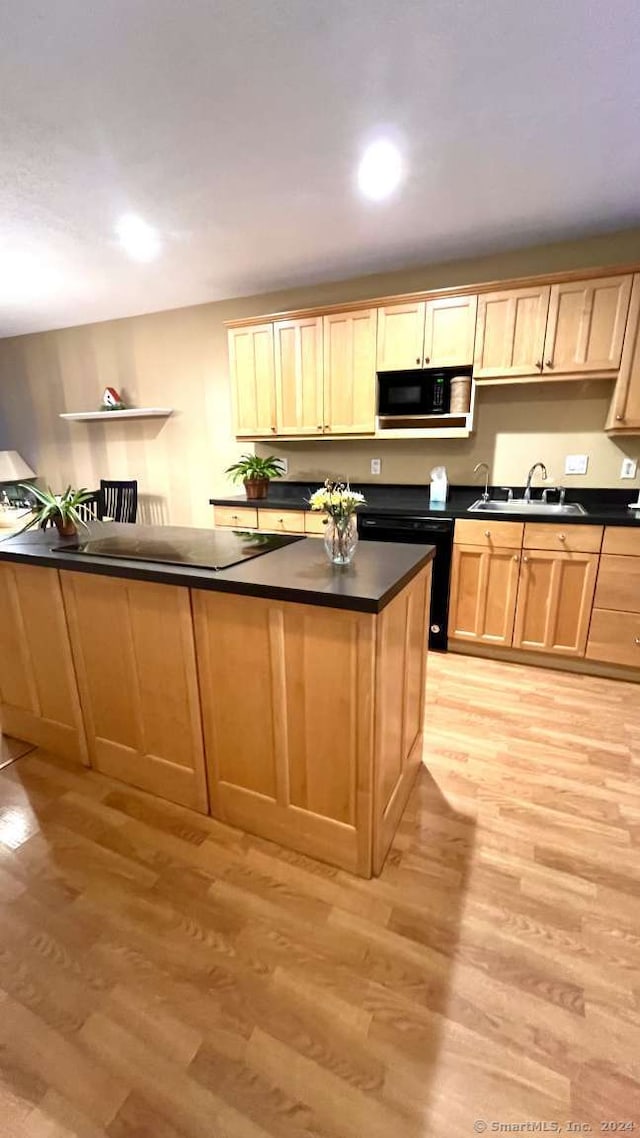 kitchen with black appliances, light wood-type flooring, and sink