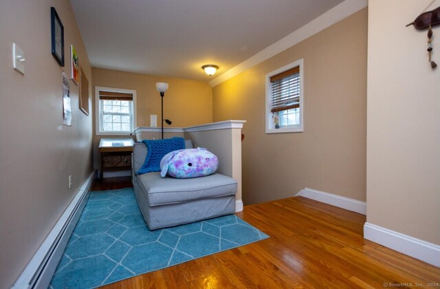 living area featuring dark hardwood / wood-style floors and a baseboard heating unit