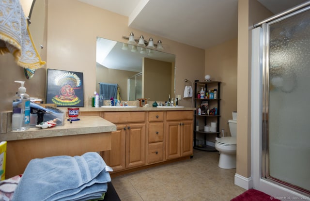 bathroom with tile patterned floors, toilet, vanity, and walk in shower