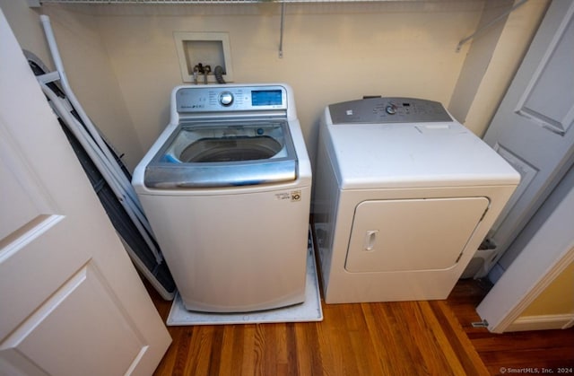 laundry room with laundry area, dark wood-style flooring, and washer and dryer