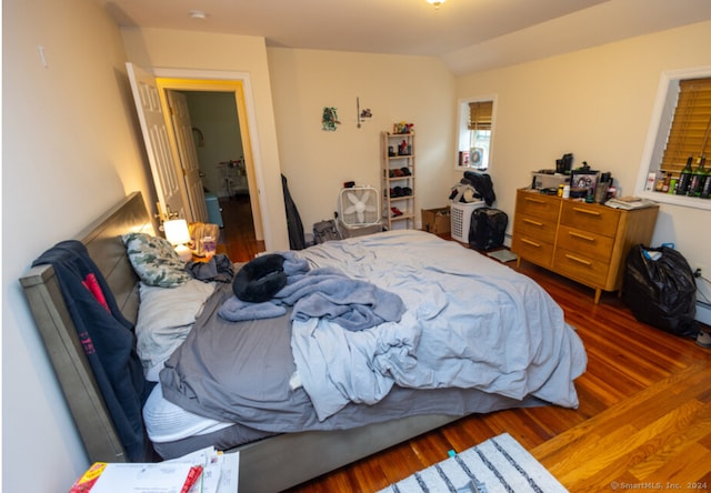 bedroom with dark hardwood / wood-style flooring and lofted ceiling