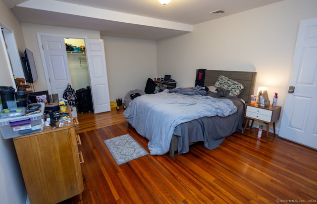 bedroom featuring dark hardwood / wood-style flooring, a spacious closet, and a closet