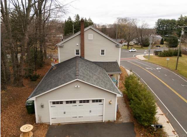 view of front of property with roof with shingles and a chimney