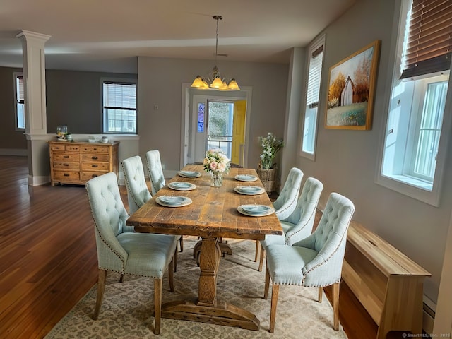 dining area with a chandelier, dark wood-type flooring, decorative columns, and baseboards