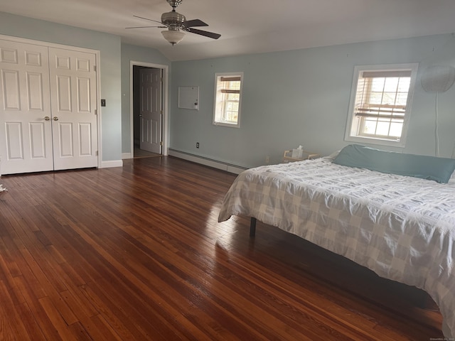 bedroom with a baseboard radiator, dark wood finished floors, lofted ceiling, and baseboards