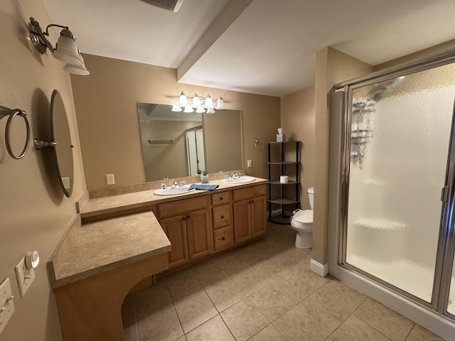 full bathroom featuring double vanity, toilet, a stall shower, a sink, and tile patterned flooring