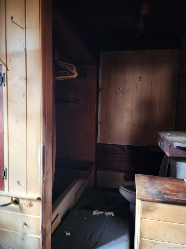 bathroom featuring toilet and wooden walls