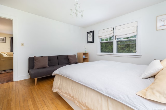 bedroom with hardwood / wood-style floors and a chandelier