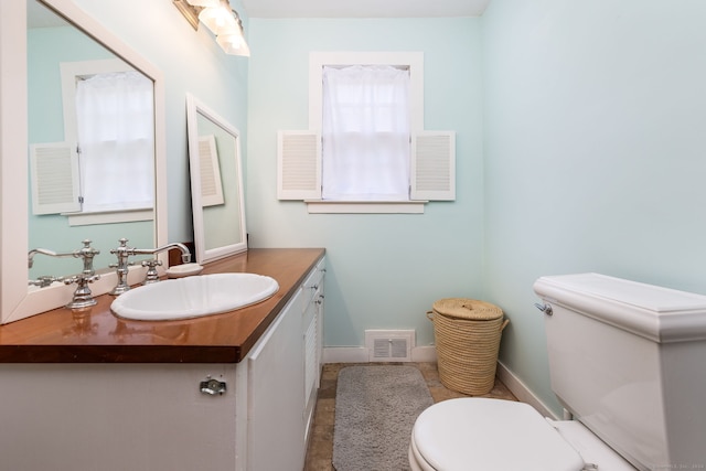 bathroom with visible vents, toilet, and vanity