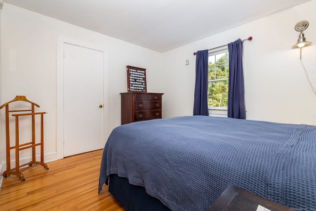 bedroom with light hardwood / wood-style floors and a closet