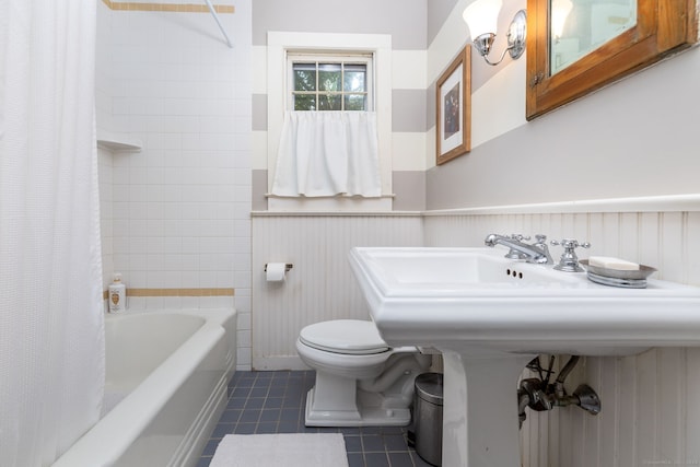 bathroom featuring wainscoting, tile patterned floors, shower / bath combo, and toilet