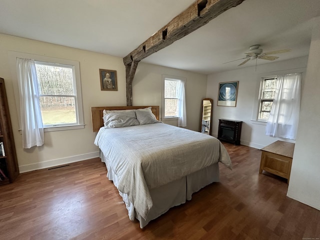 bedroom with beamed ceiling, dark hardwood / wood-style floors, and ceiling fan