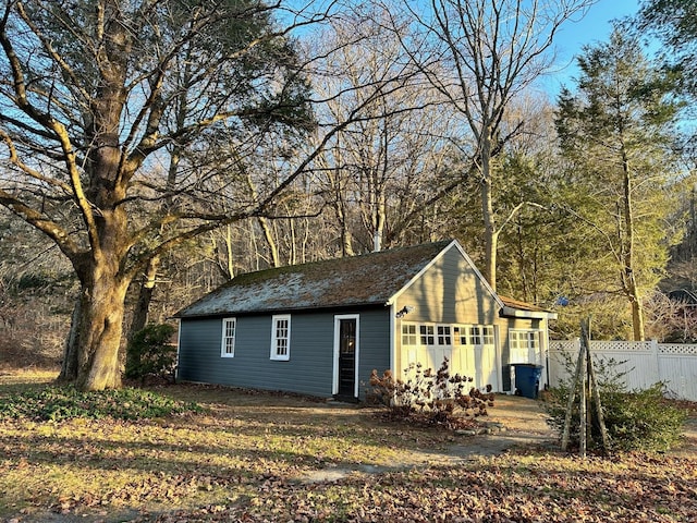 view of outdoor structure with fence and an outbuilding