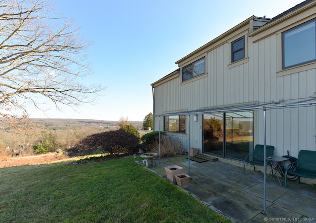 rear view of property featuring a yard and a patio