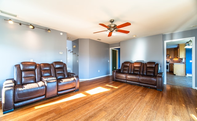 living room featuring light hardwood / wood-style floors, ceiling fan, and sink