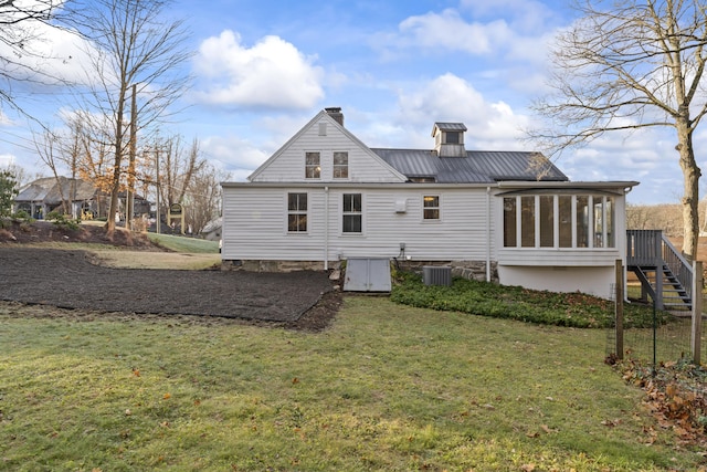 rear view of house with a sunroom and a yard