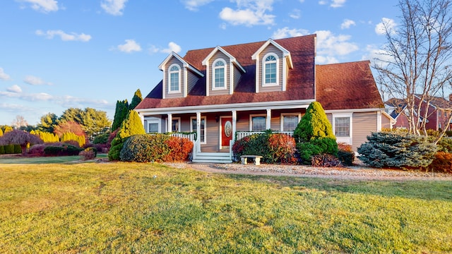 cape cod house with covered porch and a front lawn