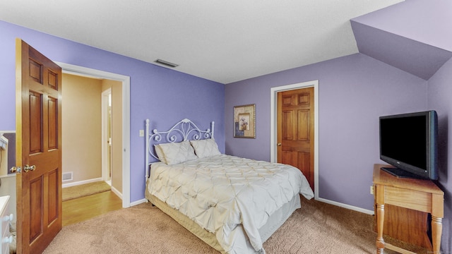 carpeted bedroom with lofted ceiling