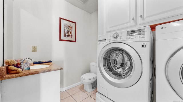 washroom with light tile patterned flooring, separate washer and dryer, and sink