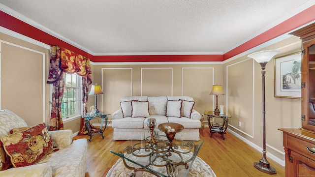 living room with a textured ceiling, light hardwood / wood-style flooring, and ornamental molding