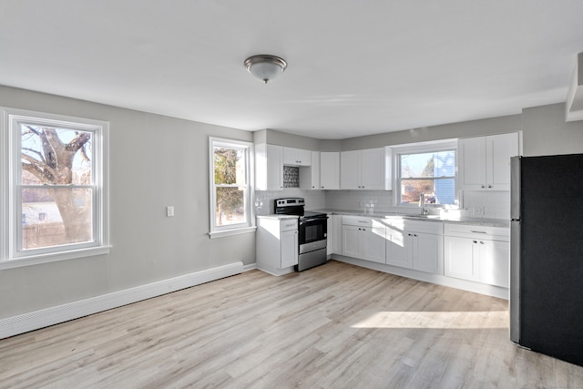 kitchen featuring white cabinets, stainless steel appliances, and a baseboard heating unit