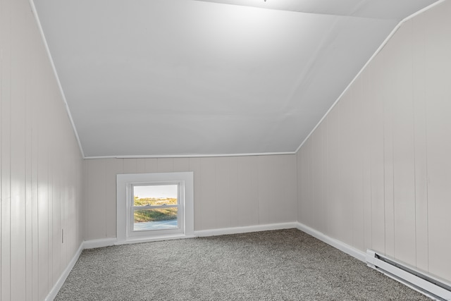 additional living space featuring baseboard heating, wood walls, carpet floors, and lofted ceiling