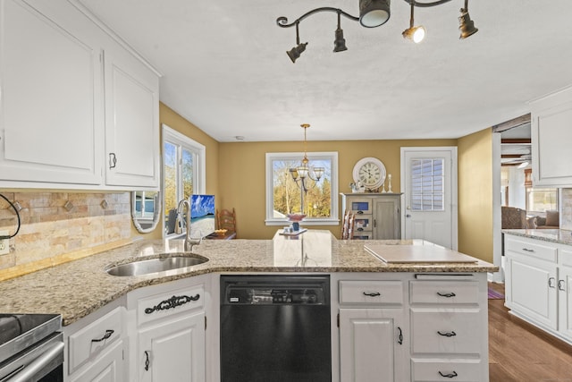 kitchen featuring pendant lighting, dishwasher, white cabinets, sink, and hardwood / wood-style flooring